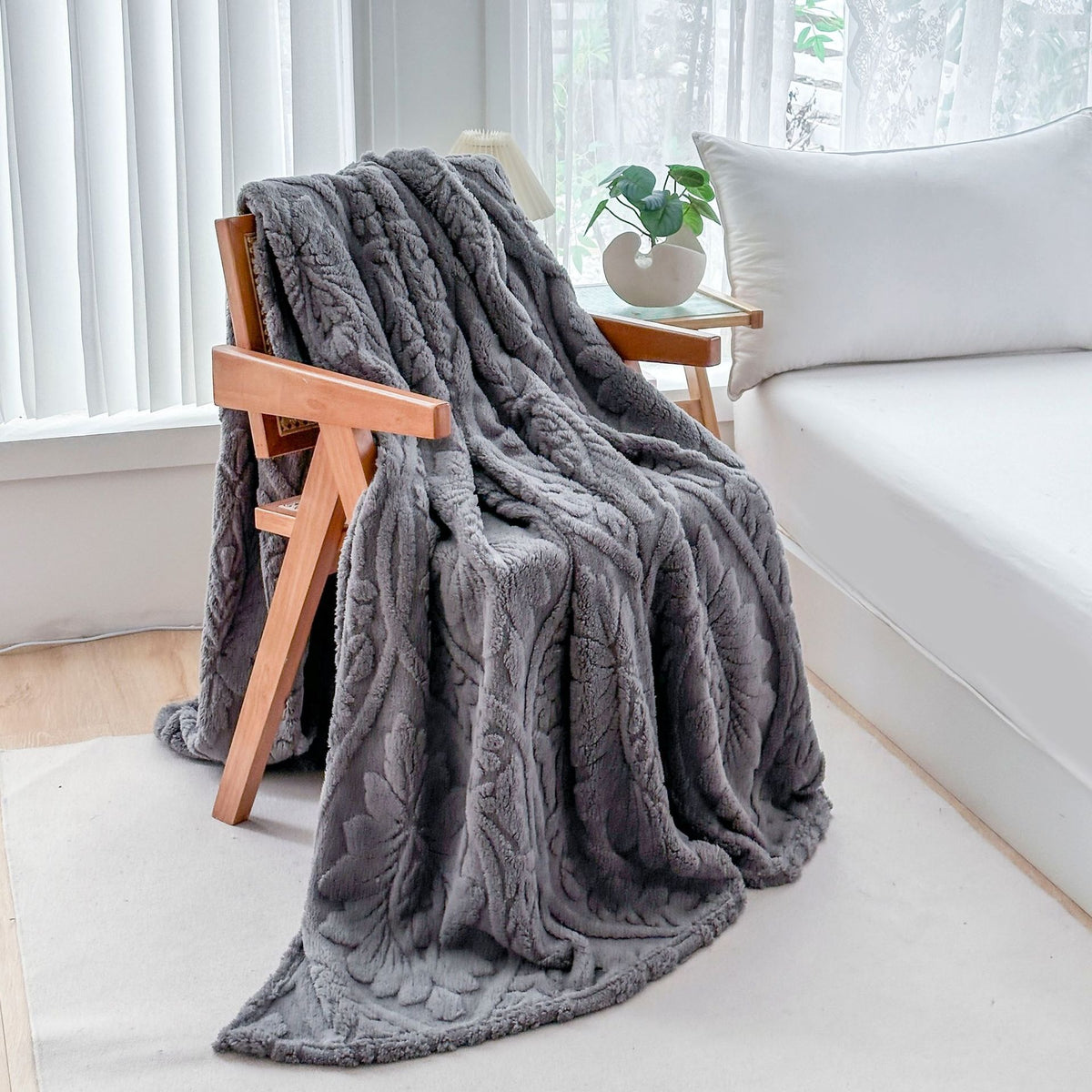 Gray fleece blanket draped over a wooden armchair