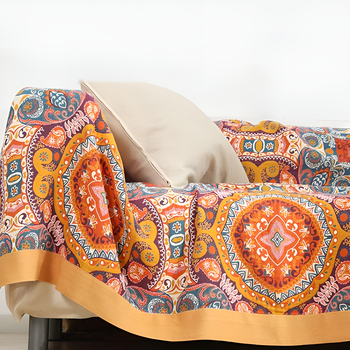 Medallion throw blanket draped over a cream couch with a pillow