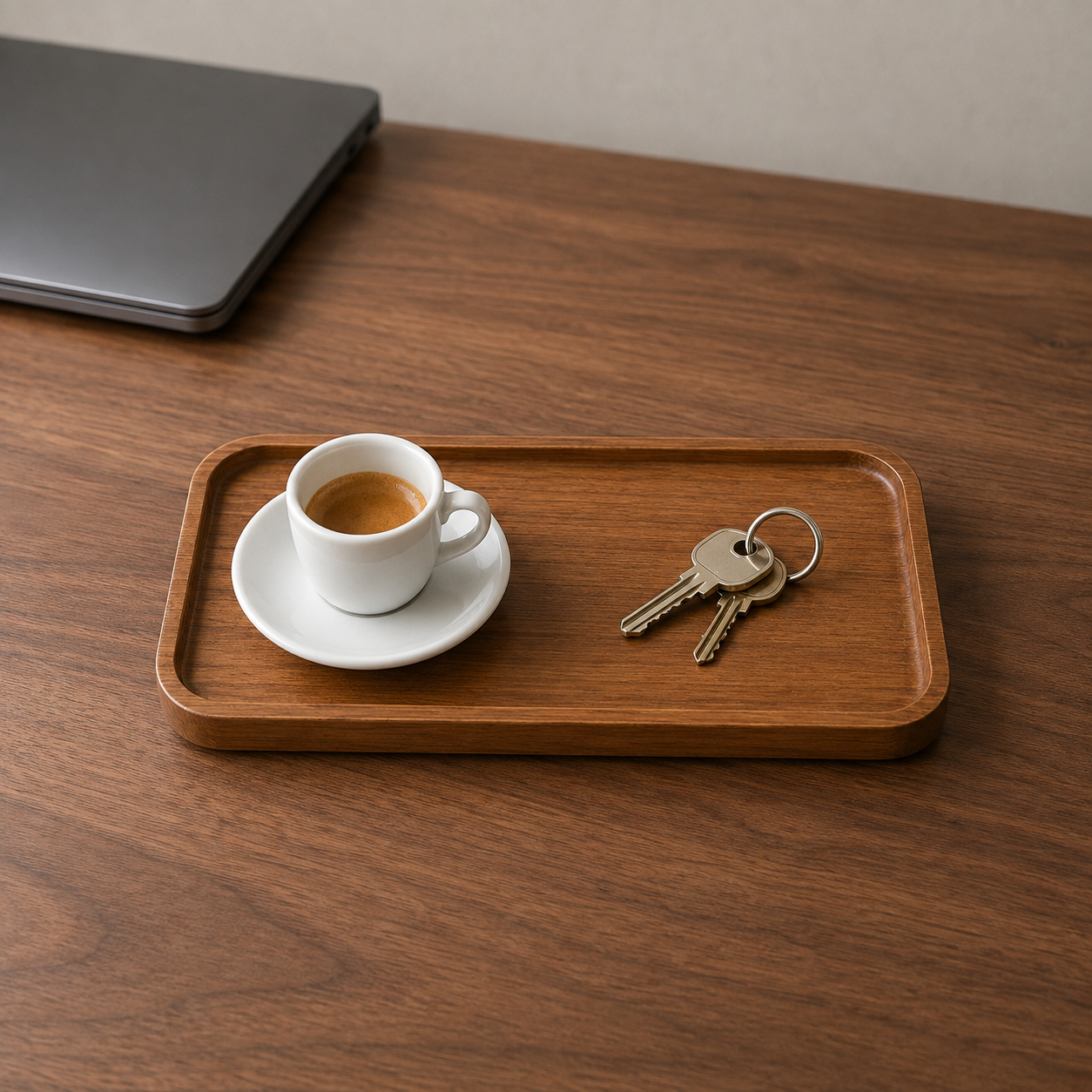 Small rectangular wooden tray on a desk with an espresso cup and keys