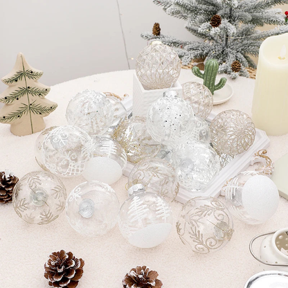 White and champagne glitter clear baubles heaped on a snowy table beside a flocked tree and a candle