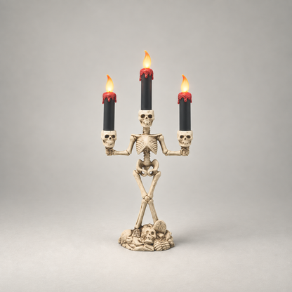 Halloween skeleton candle holder in red, three lit LED candles, on a plain grey studio background