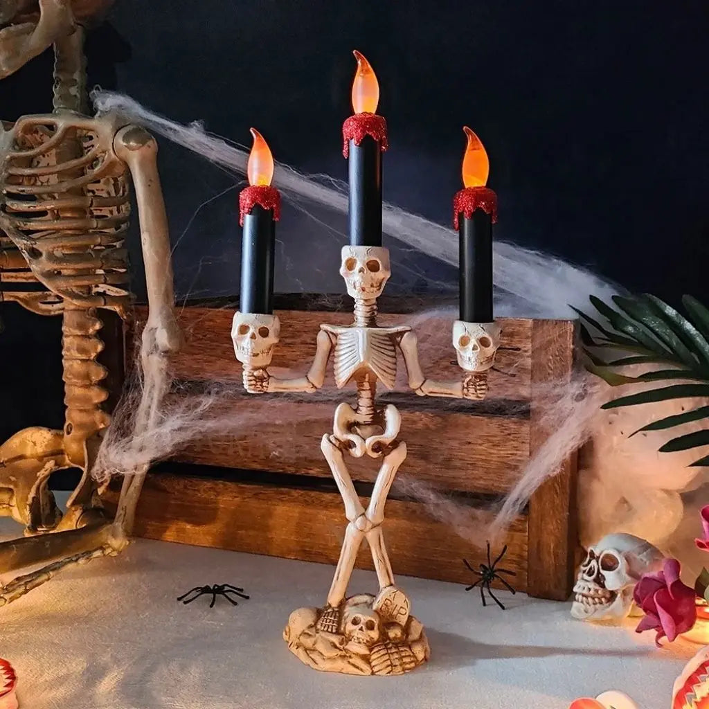 Skeleton candle holder on a wooden crate with cobwebs and a skeleton behind it