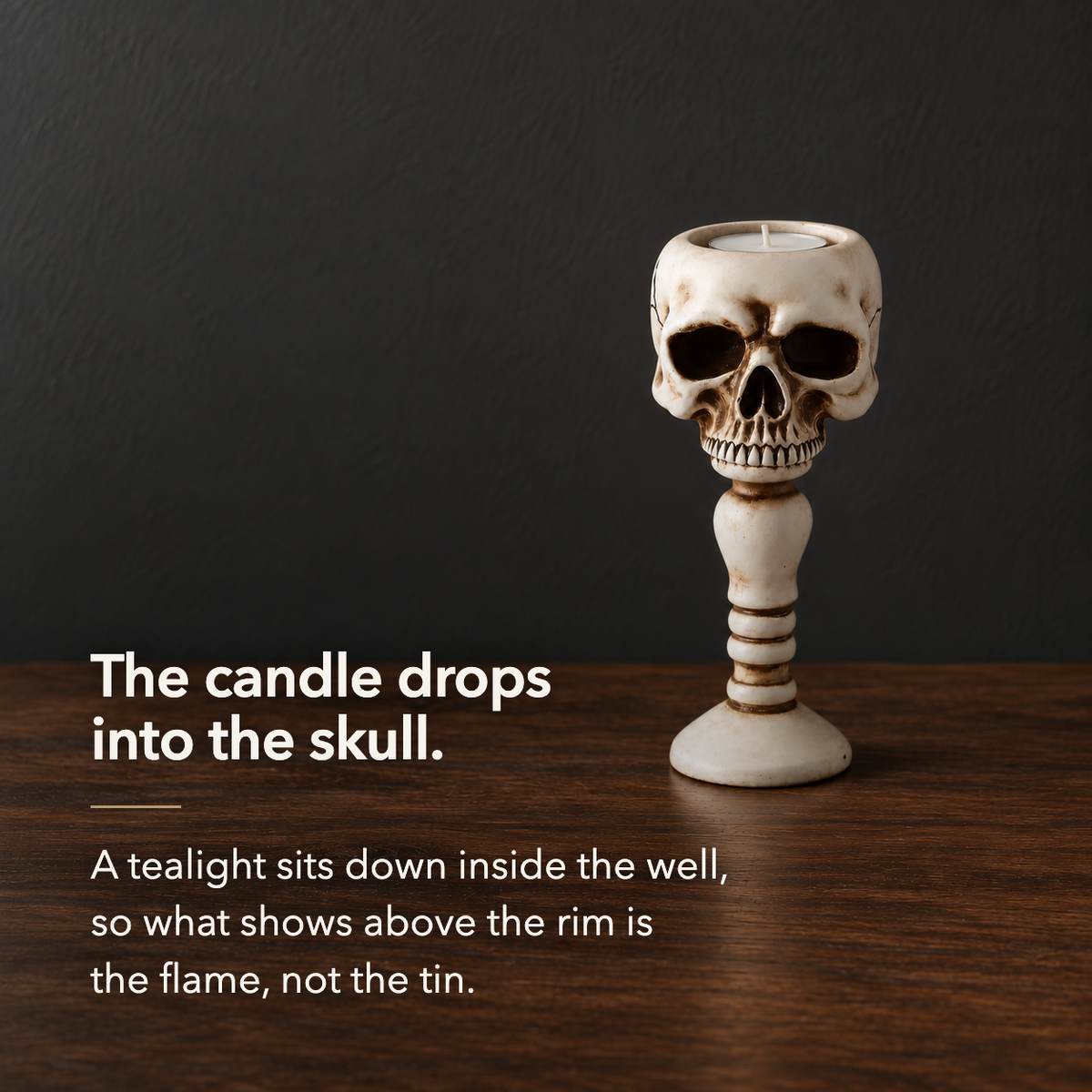 The candle drops into the skull. A tealight sits down inside the well so the flame shows above the rim