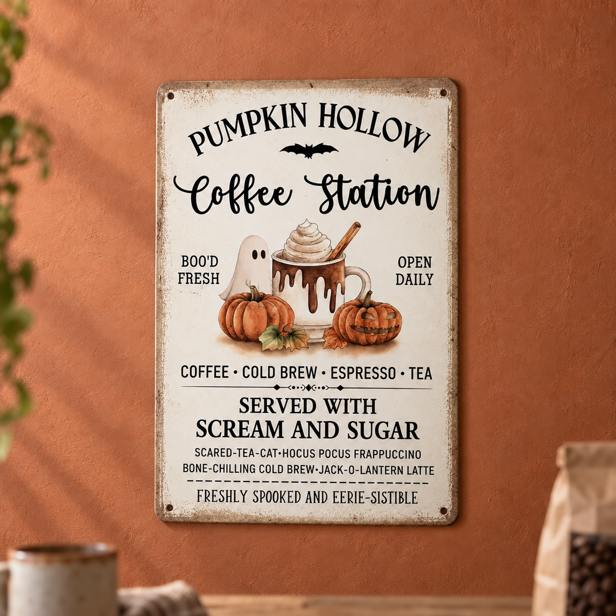 Pumpkin Hollow Coffee Station metal sign hanging centred on a warm terracotta plaster kitchen wall, reading served with scream and sugar, with a stoneware mug and a bag of coffee beans blurred along the bottom