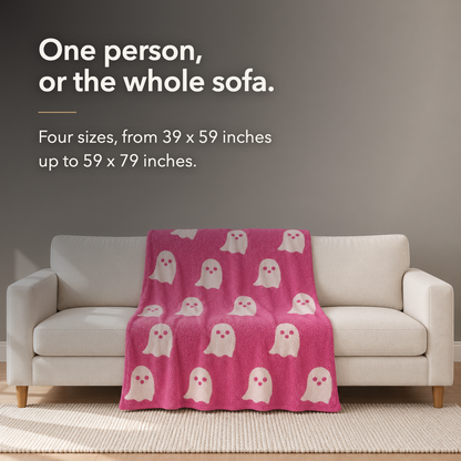 Pink ghost knit throw blanket spread across a three seat cream sofa, lettered with the words one person, or the whole sofa, and the four sizes in inches