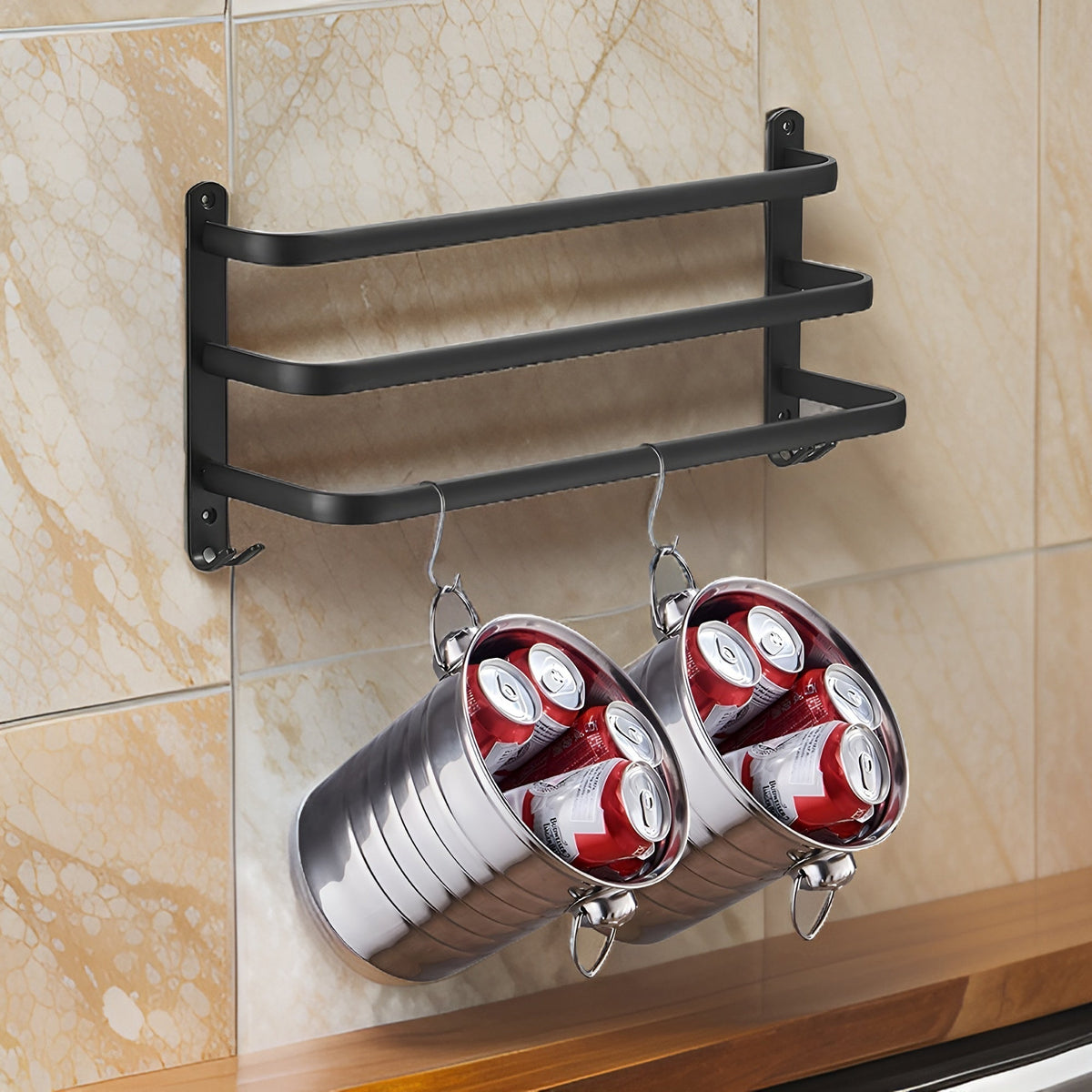 Three-bar matte black aluminum rack on a marble splashback, held by a plate at each end with a pair of small hooks under each plate, the bars stepping further out toward the bottom