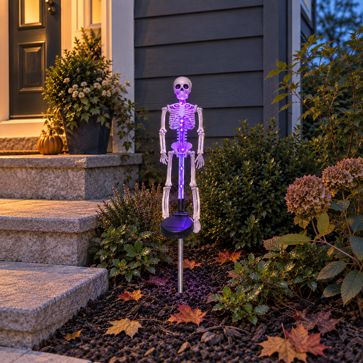 Purple solar skeleton stake light glowing in a flowerbed beside a porch step at dusk