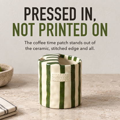 Green striped ceramic cup on a pale kitchen worktop, its raised coffee time label in close view, with the words Pressed In, Not Printed On