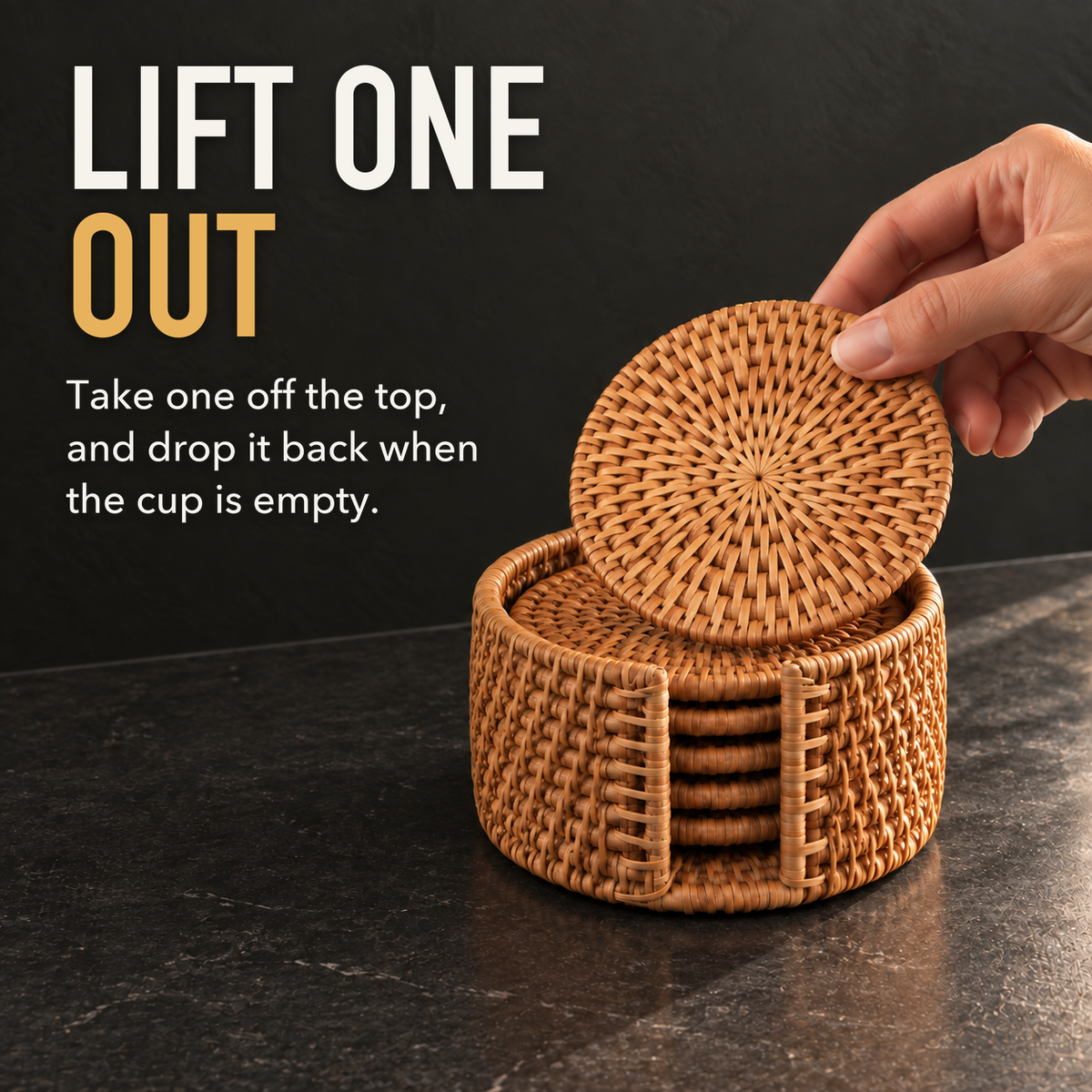 A hand lifting one woven rattan coaster out of the top of its round rattan holder on a charcoal counter, with the words Lift One Out