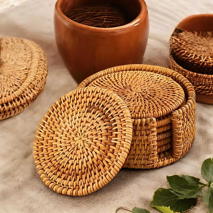 Woven rattan coasters in their round holder, with one coaster leaning against the side