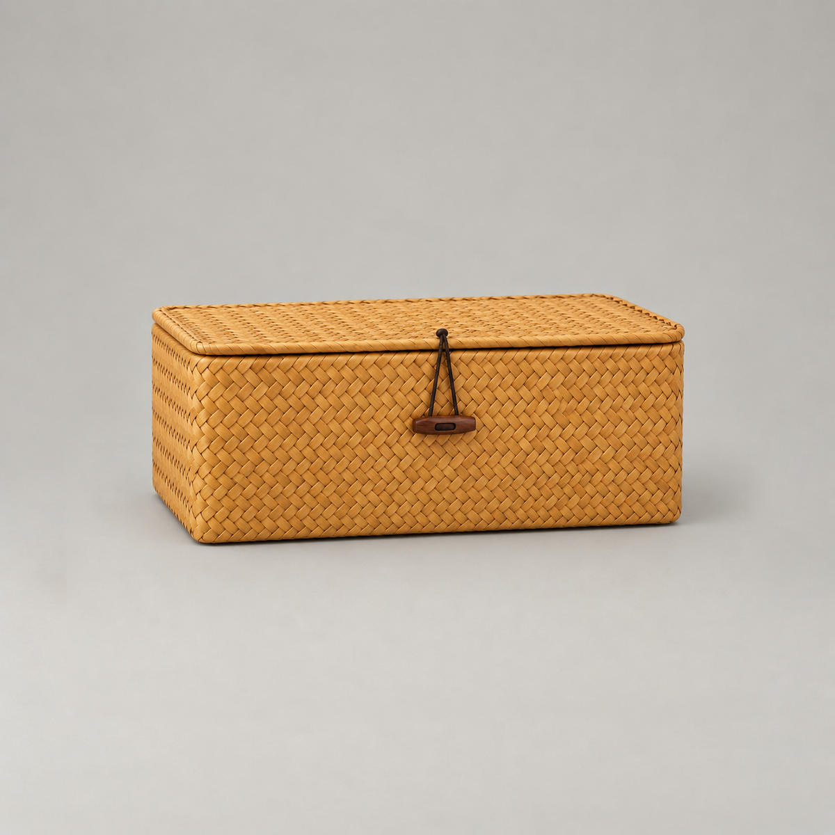 Seaweed storage basket in medium size on a plain grey background, showing the herringbone weave and loop closure