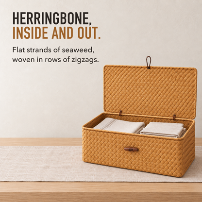 Woven seaweed storage basket with its lid standing open behind it and folded linen inside, showing the herringbone weave inside and out, with the words Herringbone, Inside and Out