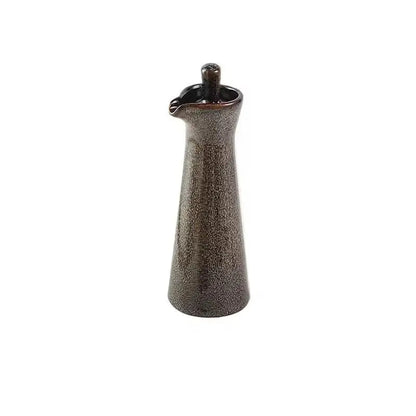 Brown speckled ceramic oil dispenser with a matching glazed stopper, standing alone on a white background