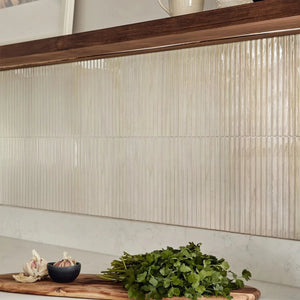 Pale wood grain peel and stick backsplash tiles in slim vertical strips on a kitchen wall between a walnut shelf and a white stone counter