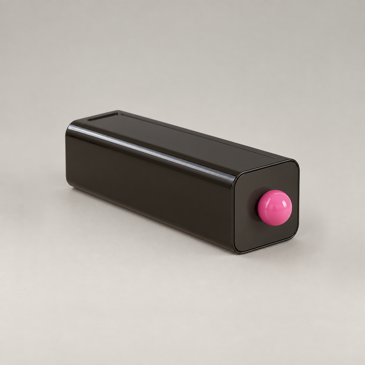Black stackable storage drawer with a pink ball knob on a plain grey background