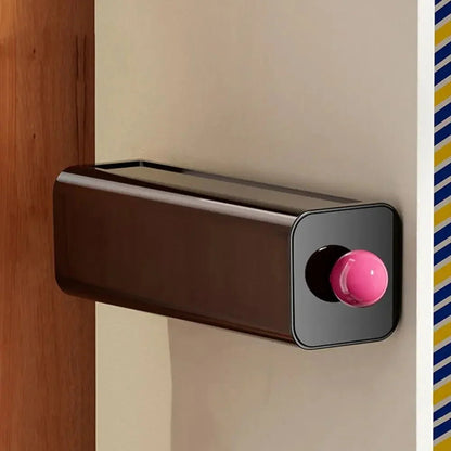 Black storage drawer with a pink ball knob mounted on a wardrobe panel