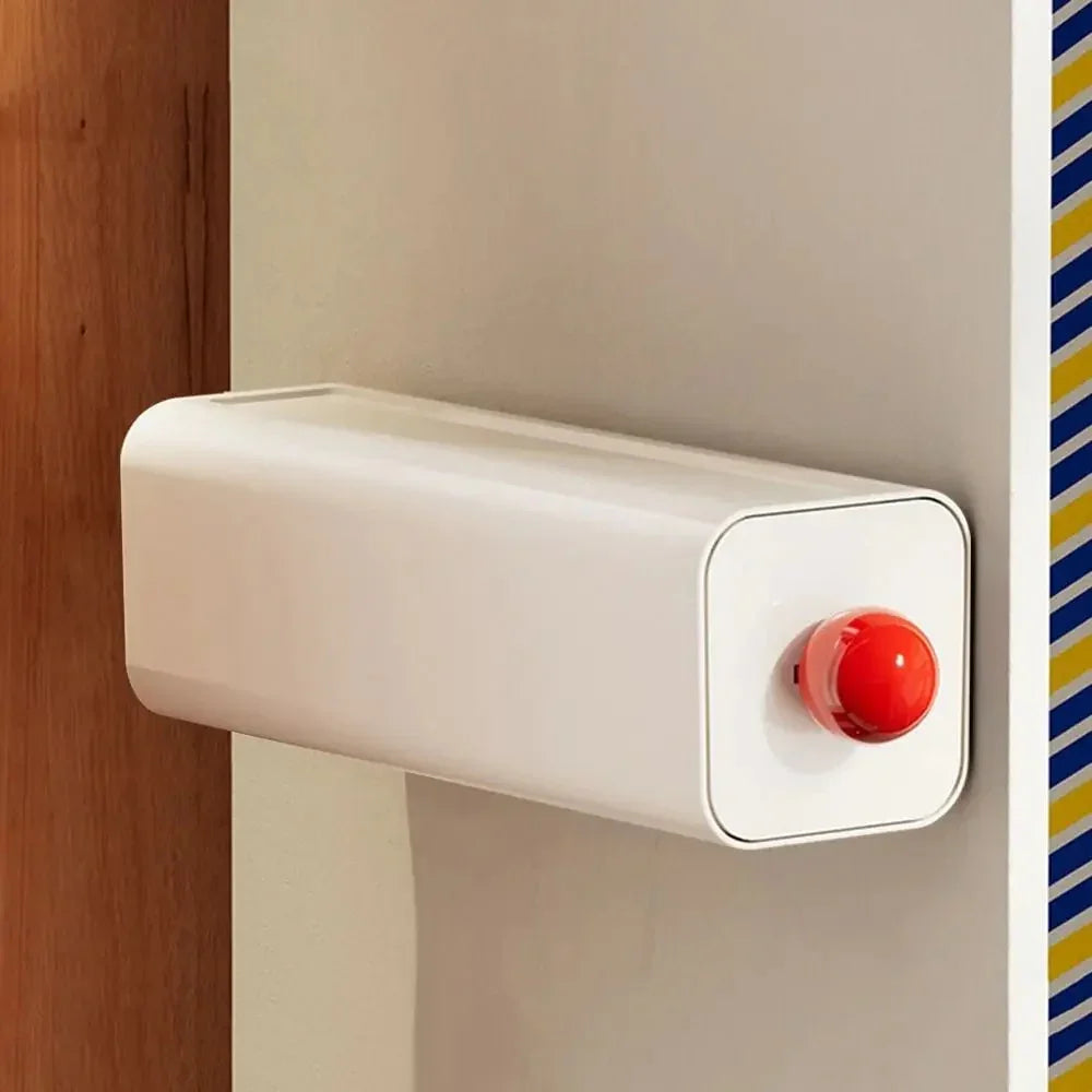 White storage drawer with a red ball knob mounted on a wardrobe panel