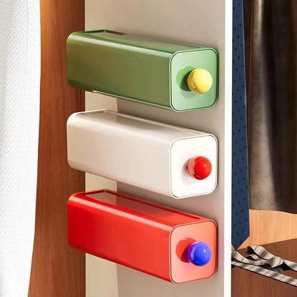 Green, white and red storage drawers mounted one above another on the side of a wardrobe