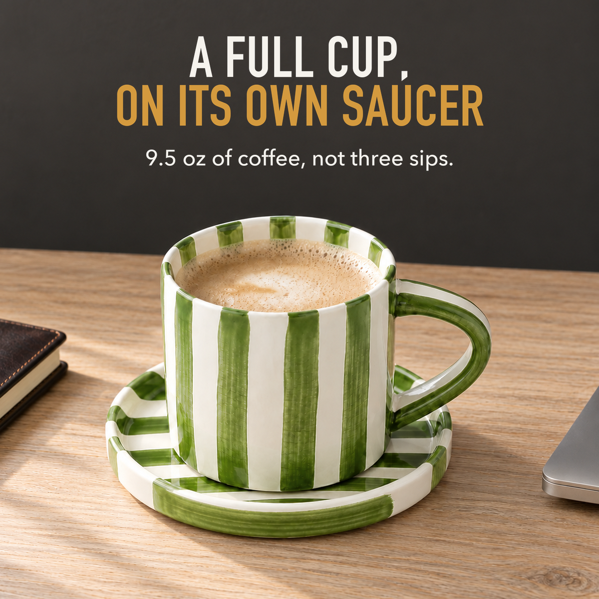 Text image: A full cup, on its own saucer. A green striped cup and saucer of milky coffee on an oak desk, 9.5 ounce capacity
