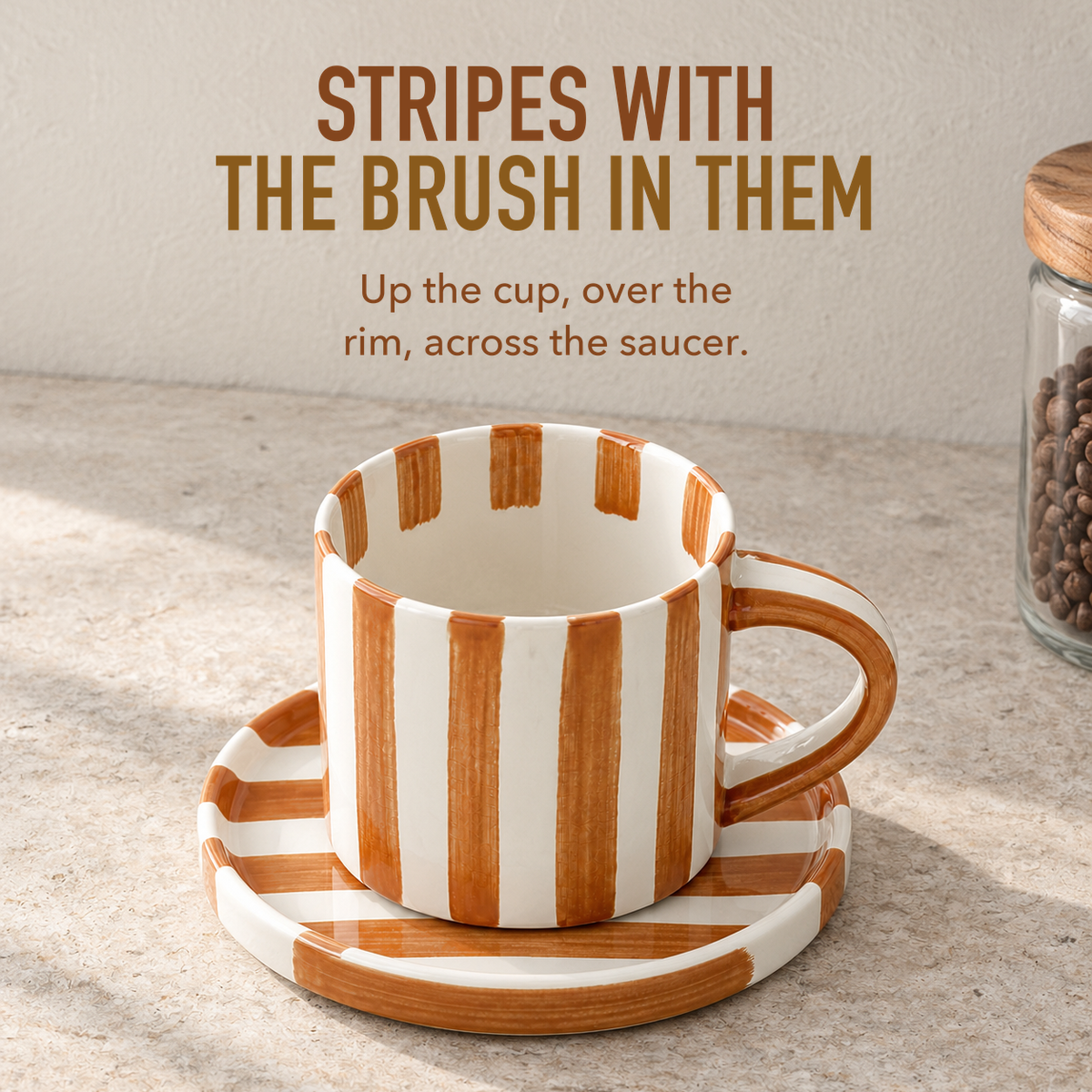 Text image: Stripes with the brush in them. An empty caramel brown striped cup on its saucer, stripes running over the rim and across the saucer