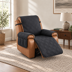 Black quilted recliner slipcover with a three-compartment arm pocket on a tan leather recliner with the footrest out, in a daylit living room
