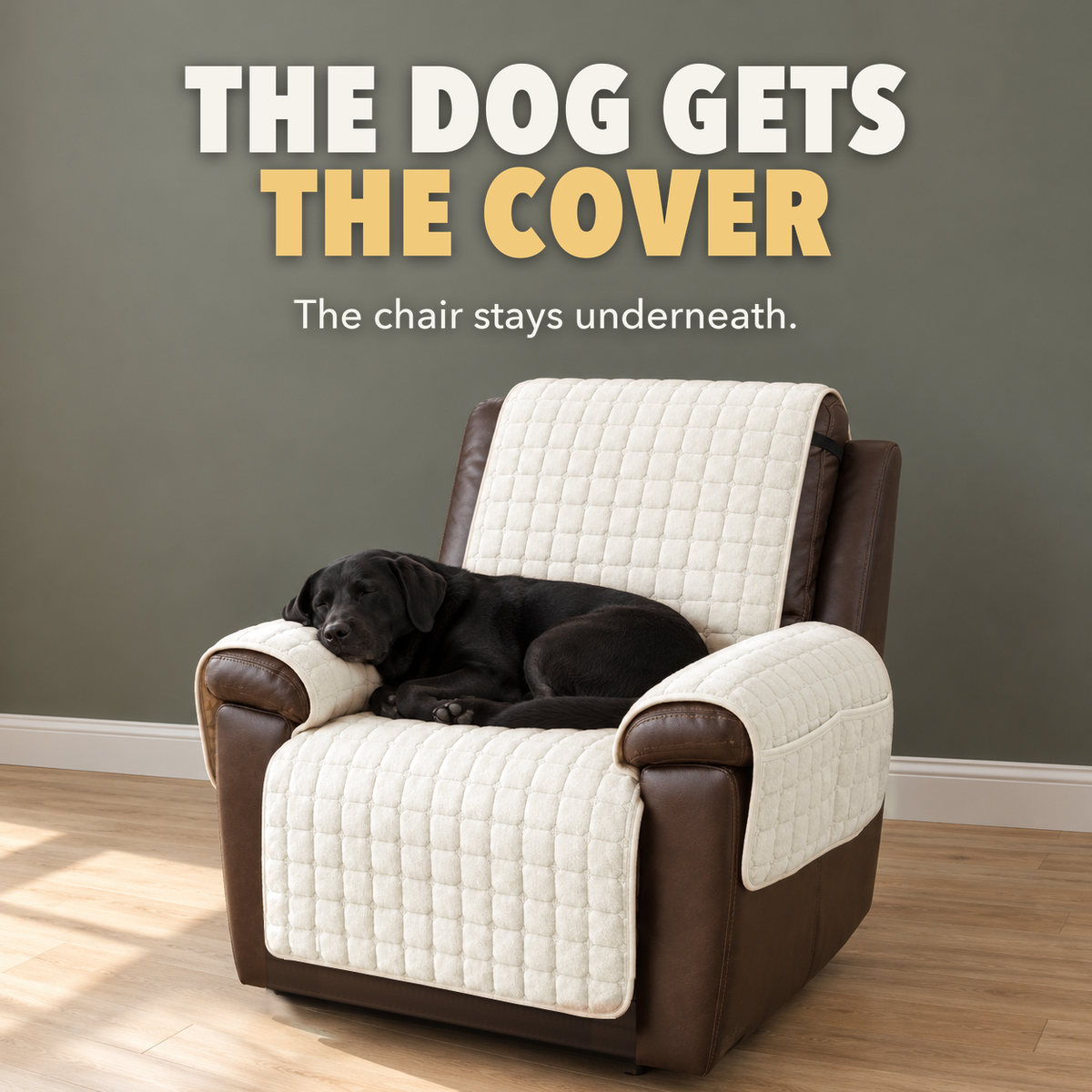 Black Labrador asleep on a beige quilted recliner cover on a dark brown leather recliner, with the words The dog gets the cover