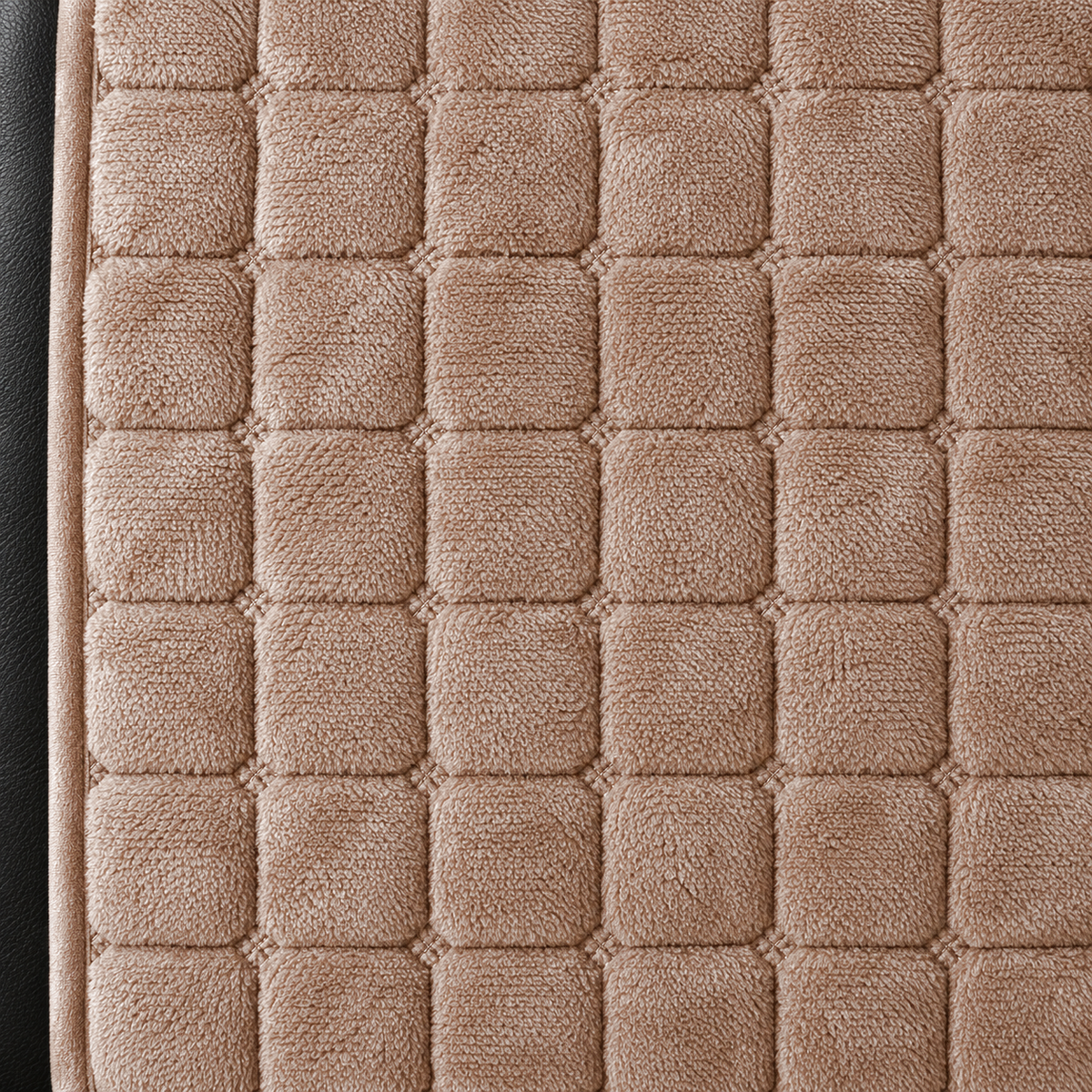 Close-up of the brown grid quilting, with a small stitched knot at each crossing