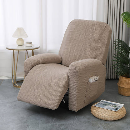 Taupe stretch recliner cover on a single recliner beside a rattan pouf with a magazine