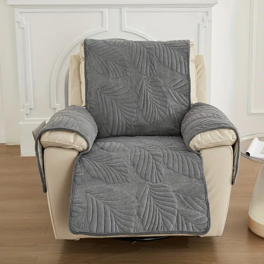 Charcoal leaf quilted recliner cover on an upright recliner against a white panelled wall