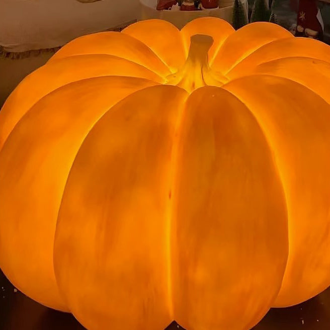 Close view of the glowing resin shell and curved stem of a solar pumpkin light