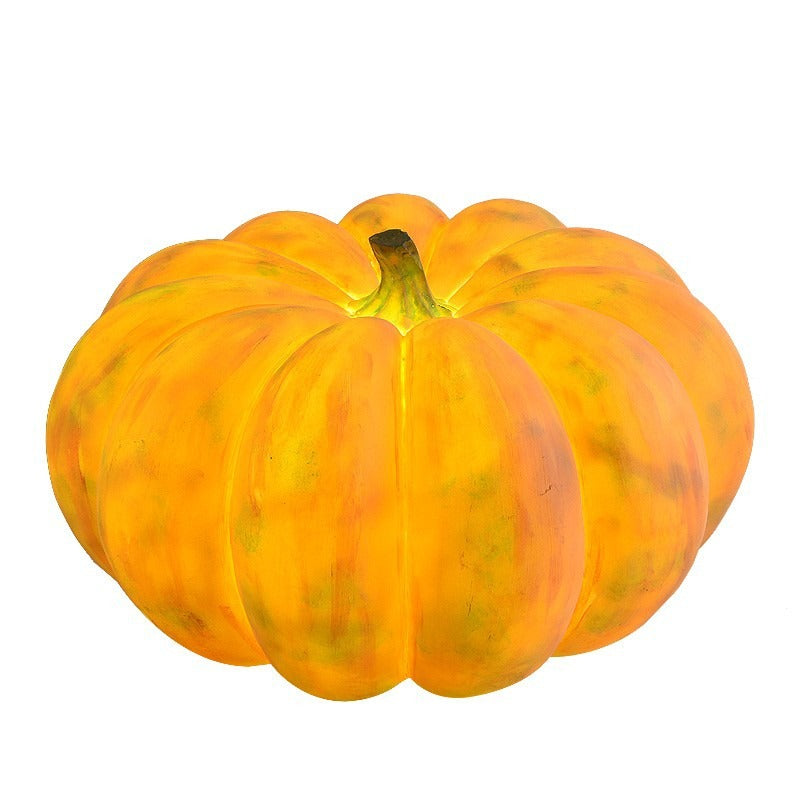 Solar pumpkin light on a white background, its streaked orange resin finish and green stem lit softly from inside