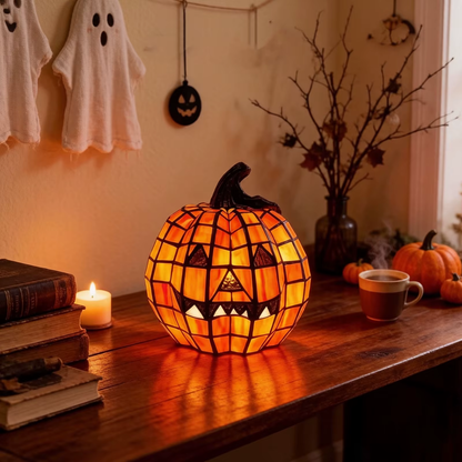 Mosaic jack-o'-lantern lamp lit on a wooden desk with old books, a candle and a cup of coffee, fabric ghosts on the wall behind