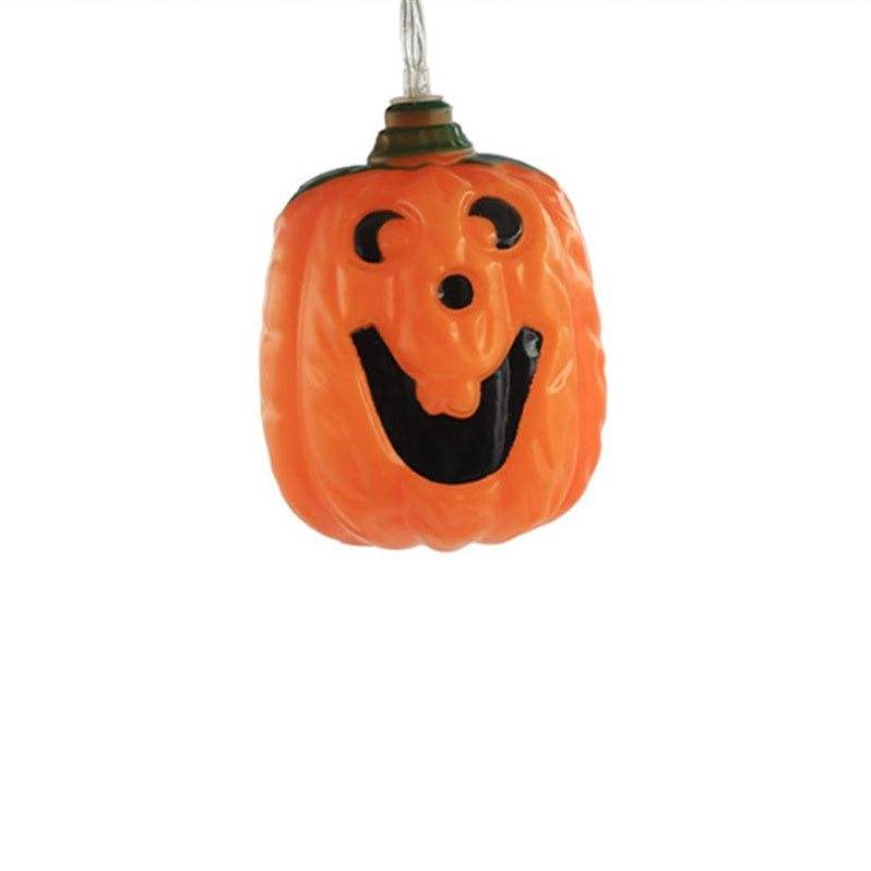 One unlit jack-o'-lantern bulb on white, orange with a black painted face and green leaves at the stem