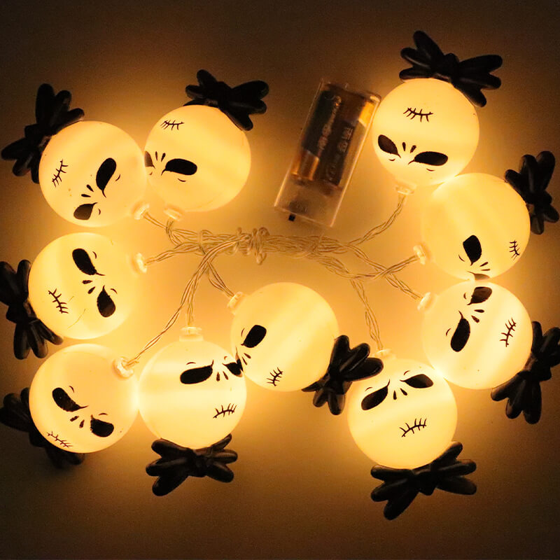 Ten lit string light heads laid in a loop around a clear battery box, seen close up