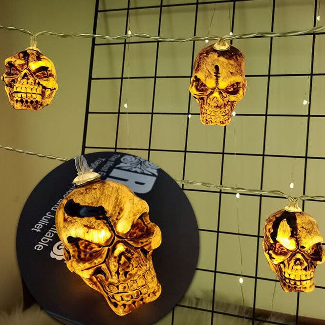 Skull string lights on a wall grid with a close-up of one glowing skull
