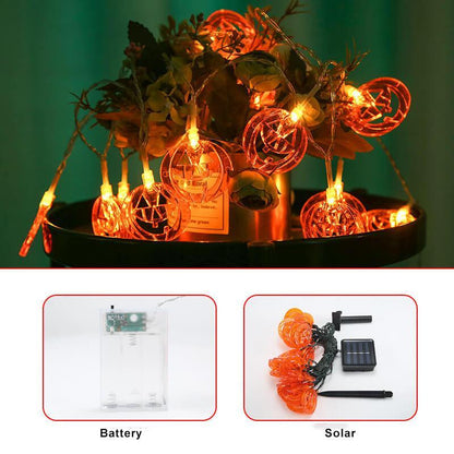 Pumpkin string lights around a planter, with the clear battery box and the solar panel, stake and wire shown below