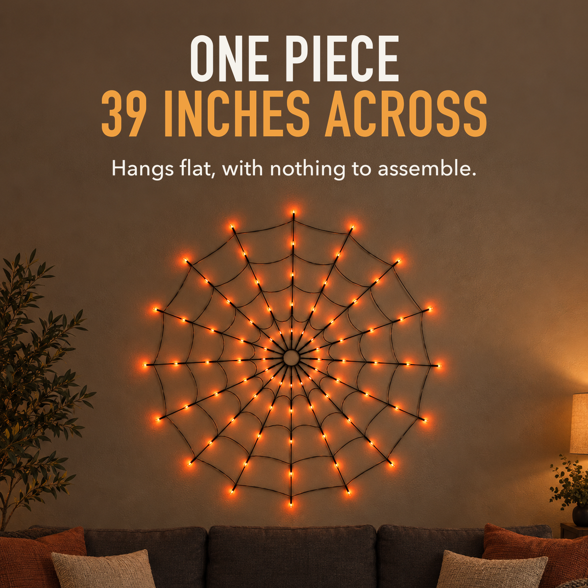 Text image: One piece, 39 inches across. Orange lit spider web light hanging on a living room wall above a sofa