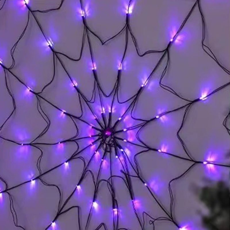 Purple lit spider web light hanging on a pale wall