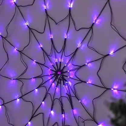 Purple lit spider web light hanging on a pale wall