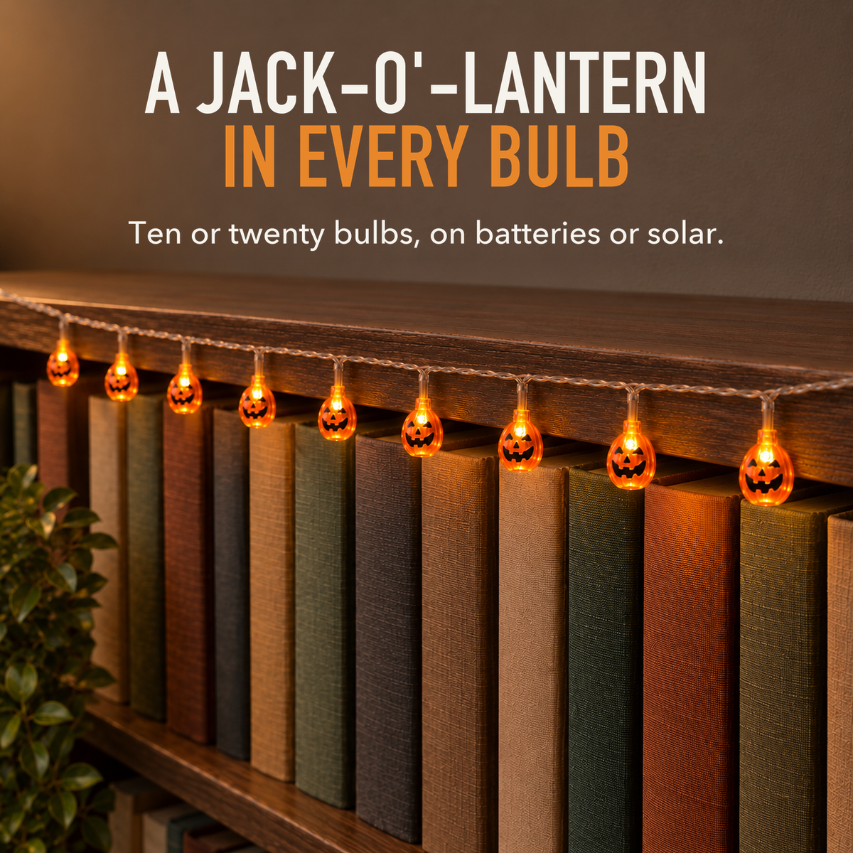 Text image: A jack-o'-lantern in every bulb. Lit orange pumpkin string lights on a clear wire hanging along a walnut bookcase in the evening