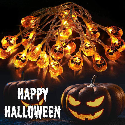 A tangle of lit orange jack-o'-lantern string lights above two carved pumpkins, with Happy Halloween lettering