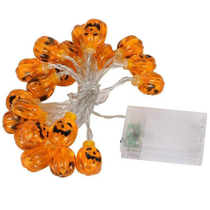 Unlit orange jack-o'-lantern string lights bundled on a clear wire beside a clear battery box