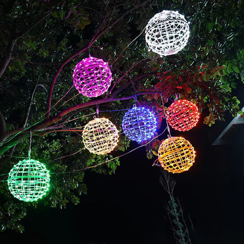 LED ball lights in green, pink, warm white, blue, red, yellow and white hanging in a tree at night