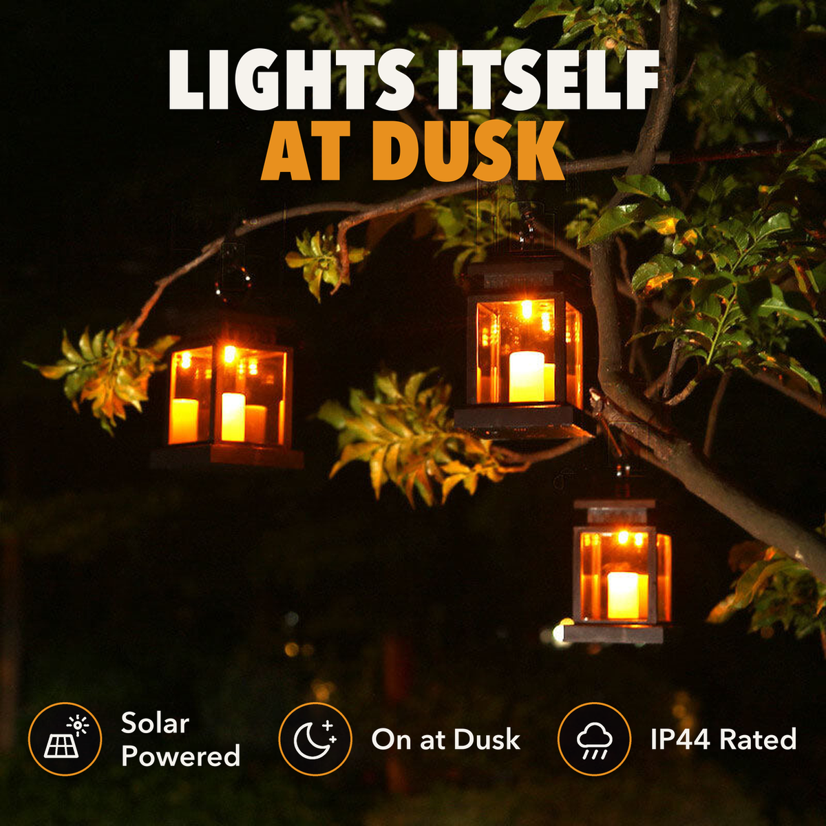 Three solar candle lanterns glowing in a tree at night, with the words lights itself at dusk, solar powered, on at dusk and IP44 rated