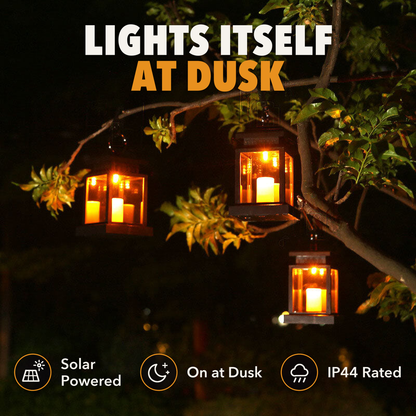 Three solar candle lanterns glowing in a tree at night, with the words lights itself at dusk, solar powered, on at dusk and IP44 rated