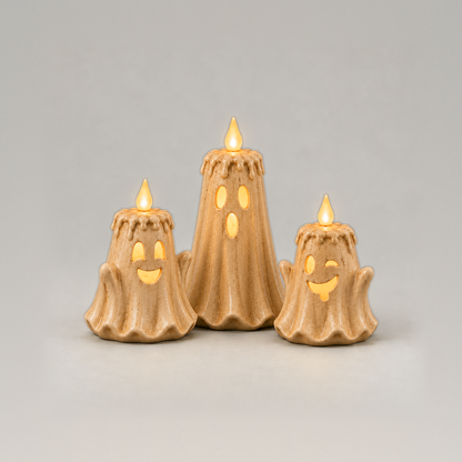 Set of three ghost LED candles, surprised, grinning and winking faces glowing, on a plain grey background