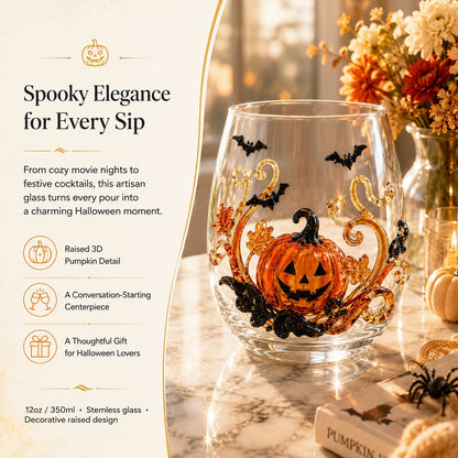 A Halloween pumpkin drinking glass on a marble table beside autumn flowers