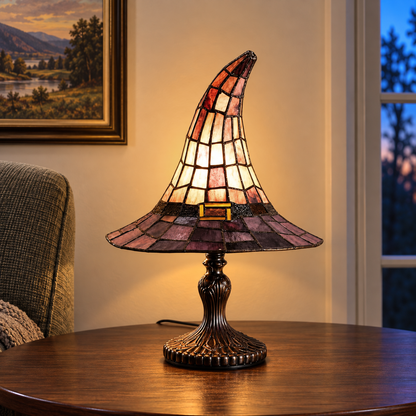 Witch hat table lamp lit on a round side table in a reading corner in the early evening, beside an armchair