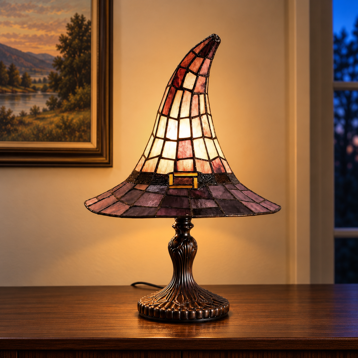 Large witch hat table lamp lit on a dining room sideboard in the evening, below a framed landscape painting