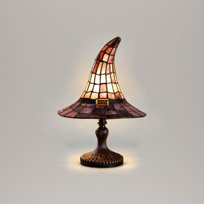 Witch hat table lamp switched on, front view, on a plain grey background